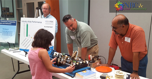 NRC Region III staff members talk with a young member of the community during the annual assessment event for DC Cook nuclear plant in Michigan.